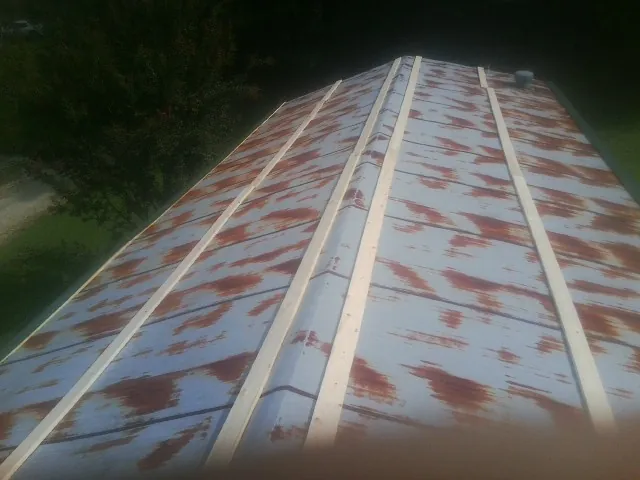 Rusted metal roof panels with new wood purlins before replacement — Storm Damage Roof Repair in Brewster by Roofing Brothers